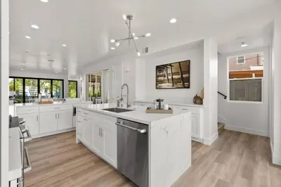 a large kitchen with white cabinets and a sink at Modern, Spacious, home w rooftop view in San Diego
