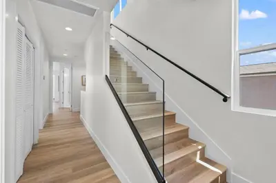 a staircase in a house with a glass railing at Modern, Spacious, home w rooftop view in San Diego