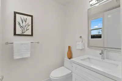 a white bathroom with a sink and a mirror at Modern, Spacious, home w rooftop view in San Diego