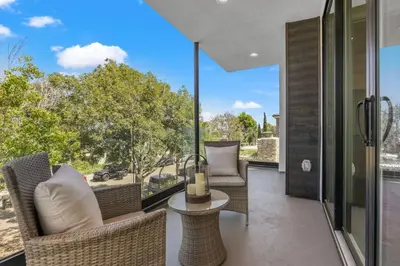 an outdoor patio with wicker chairs and a table at Modern, Spacious, home w rooftop view in San Diego