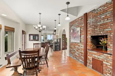 a dining room and living room with a brick wall at Casa Solana water views family friendly in Solana Beach