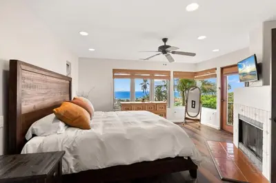 a bedroom with a bed with a fireplace and a television at Casa Solana water views family friendly in Solana Beach