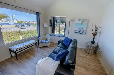 a living room with a couch and a large window at Monthly rental, Coronado Resort Style Town Home in San Diego