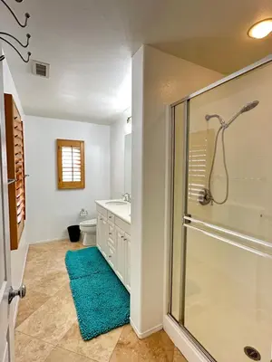 a bathroom with a glass shower and a blue rug at Comfort Retreat 3B3B Villa in Quail Hill Irvine in Irvine