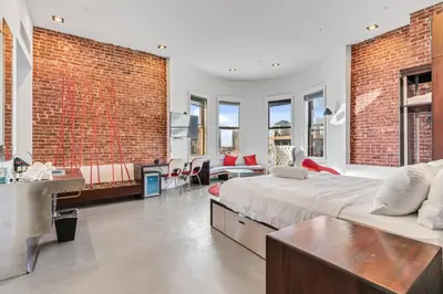 a bedroom with a large bed and a brick wall at The Keating in San Diego