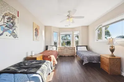 a bedroom with two beds and a ceiling fan at Coastal Haven in Oceanside- Cozy Beach Getaway home in Oceanside