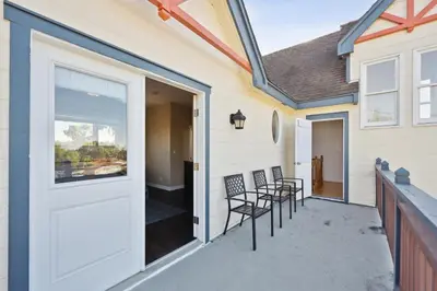 a porch with chairs and a door on a house at Coastal Haven in Oceanside- Cozy Beach Getaway home in Oceanside