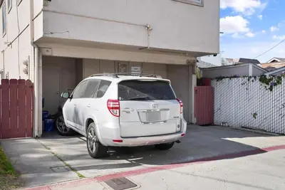 a white suv parked in front of a garage at Mission Bay Condo - Steps to Sand, Dining, AC, Parking & Shops! in San Diego