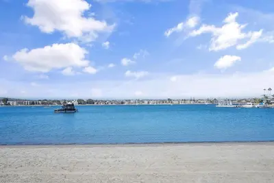 a boat in the middle of a large body of water at Mission Bay Condo - Steps to Sand, Dining, AC, Parking & Shops! in San Diego