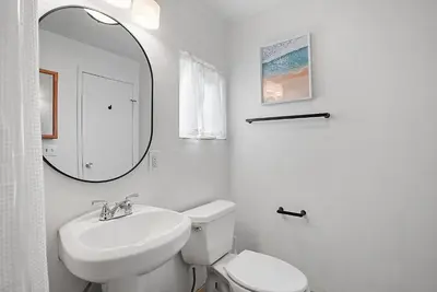 a bathroom with a sink and a toilet and a mirror at Mission Bay Condo - Steps to Sand, Dining, AC, Parking & Shops! in San Diego