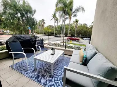 a patio with a couch and a table on a balcony at Upscale Modern Townhouse at Balboa Park in San Diego