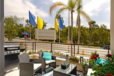 a balcony with chairs and a grill and palm trees at Upscale Modern Townhouse at Balboa Park in San Diego