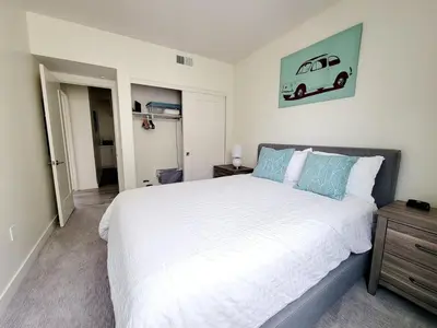 a bedroom with a large white bed with blue pillows at Upscale Modern Townhouse at Balboa Park in San Diego