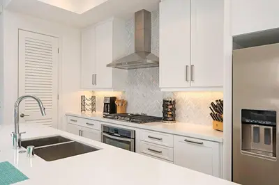 a white kitchen with white cabinets and a sink at Upscale Modern Townhouse at Balboa Park in San Diego