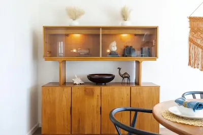 a wooden cabinet in a dining room with a table at Sunset Serenity On The Cliffs - Balcony- Oceanview in San Diego