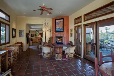 a restaurant with a bar with chairs and a fireplace at Borrego Valley Inn in Borrego Springs