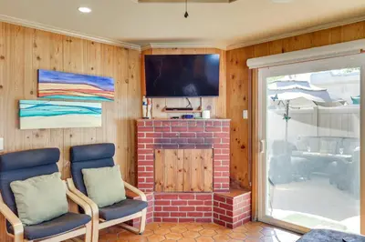 a living room with two chairs and a fireplace at Downtown Carlsbad Apartment Less Than half Mi to Beach! in Carlsbad