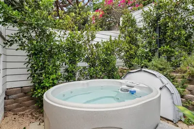 a hot tub in a garden with bushes at Neptune Hidden Gem in Encinitas