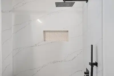 a bathroom with white marble walls and a window at Neptune Hidden Gem in Encinitas