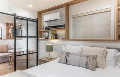 a bedroom with a bed with a window and a table at Neptune Charm in Encinitas