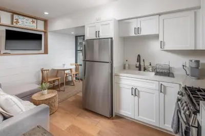 a kitchen with a stainless steel refrigerator and a table at Neptune Charm in Encinitas