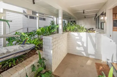 a home with a brick wall and plants at Neptune Charm in Encinitas