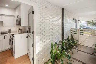 a kitchen with white walls and a brick wall at Neptune Charm in Encinitas