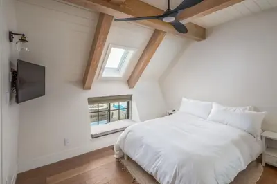 a bedroom with a white bed and a ceiling fan at Neptune Ocean View Masterpiece in Encinitas