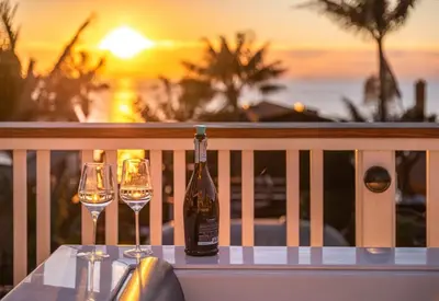 a bottle of wine sitting on a table with two glasses at Neptune Ocean View Masterpiece in Encinitas