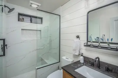 a bathroom with a glass shower and a sink at Neptune Ocean View Masterpiece in Encinitas