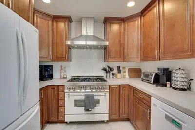 a kitchen with wooden cabinets and a stove top oven at San Diego Home Private Outdoor Pool and Game Room! in San Diego