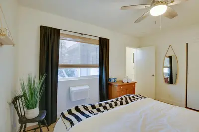 a bedroom with a bed with a ceiling fan and a window at San Diego Home Private Outdoor Pool and Game Room! in San Diego