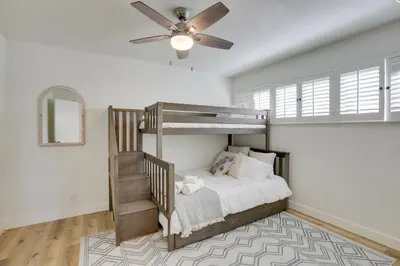a bedroom with a bunk bed with a ceiling fan at San Diego Home Private Outdoor Pool and Game Room! in San Diego