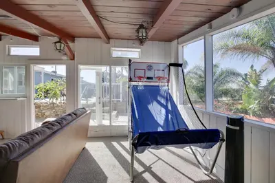 a room with a hammock in a room with windows at San Diego Home Private Outdoor Pool and Game Room! in San Diego