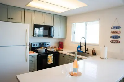 a kitchen with a white refrigerator and a white counter top at 1 Block from Beach - Steps from Restaurants & Shops in Oceanside