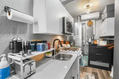 a kitchen with white cabinets and a sink at Luxury Cozy Studio with Firepit in Vista