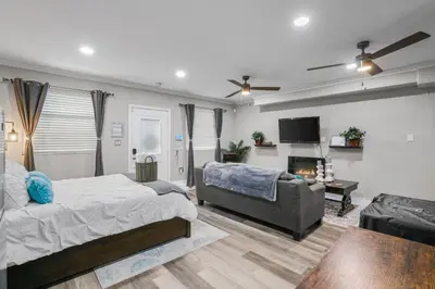 a bedroom with a bed and a couch and a fireplace at Luxury Cozy Studio with Firepit in Vista