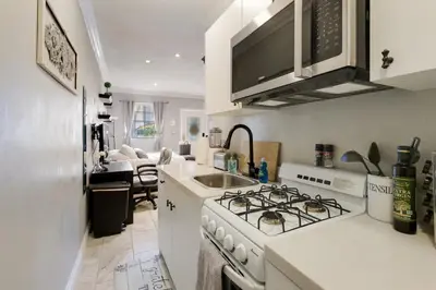 a white kitchen with a stove and a sink at Luxury Cozy Studio with Firepit in Vista