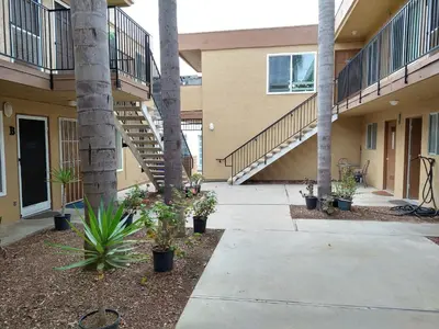 a walkway in front of a building with palm trees at Charming 1Bedroom Vacation Condo in Oceanside