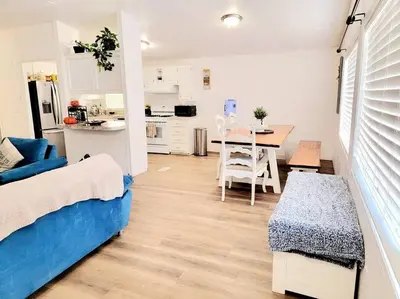 a room with a bed and a kitchen with a table at The Blue Cove in Hemet
