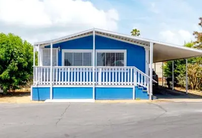 a blue house with a white porch at The Blue Cove in Hemet
