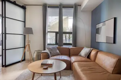 a living room with a brown couch and a table at East Village 1br w spa media room nr stadium SAN-37 in San Diego