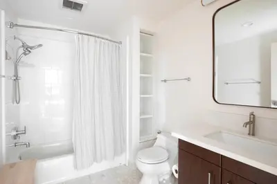 a white bathroom with a tub and a toilet and a sink at East Village 1br w spa media room nr stadium SAN-37 in San Diego