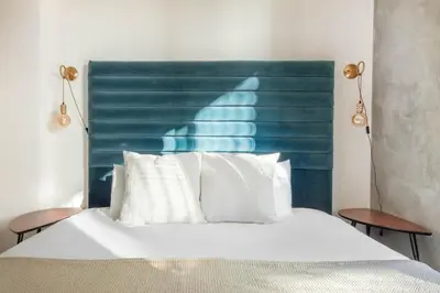a bed with a blue headboard and white pillows at East Village 1br w spa media room nr stadium SAN-37 in San Diego