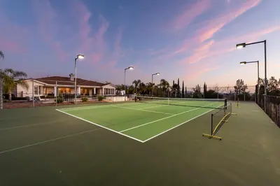 a tennis court with a net on top of it at Luxury Home With Pool & Tennis Court in Fallbrook