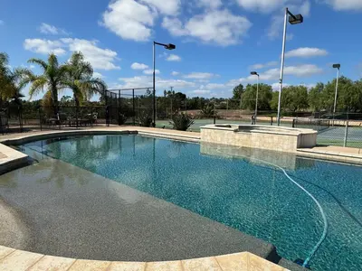 a swimming pool with blue water in a park at Luxury Home With Pool & Tennis Court in Fallbrook
