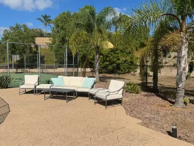 a group of lounge chairs sitting on a tennis court at Luxury Home With Pool & Tennis Court in Fallbrook
