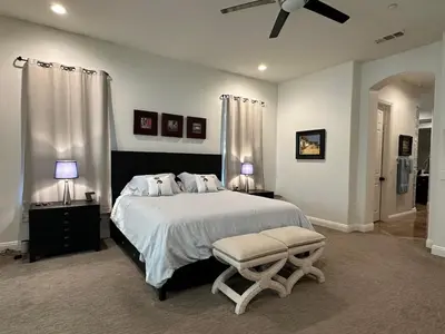 a bedroom with a large bed and a ceiling fan at Luxury Home With Pool & Tennis Court in Fallbrook