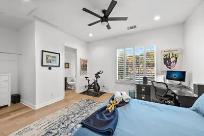 a bedroom with a bed with a desk and a ceiling fan at Luxury Home With Pool & Tennis Court in Fallbrook