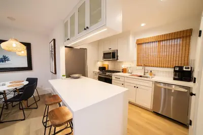 a kitchen with white cabinets and a white counter top at Luxury 2BR Steps to Beach & Pier with AC plus Garage Parking in Newport Beach